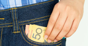 Man taking Australian money out of jeans pocket