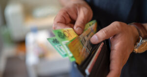 man's hands opening wallet with Australian money